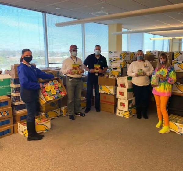 People in room with food drive donations