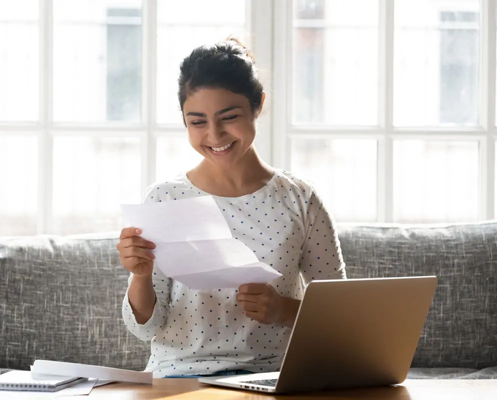 woman smiling while reading paper