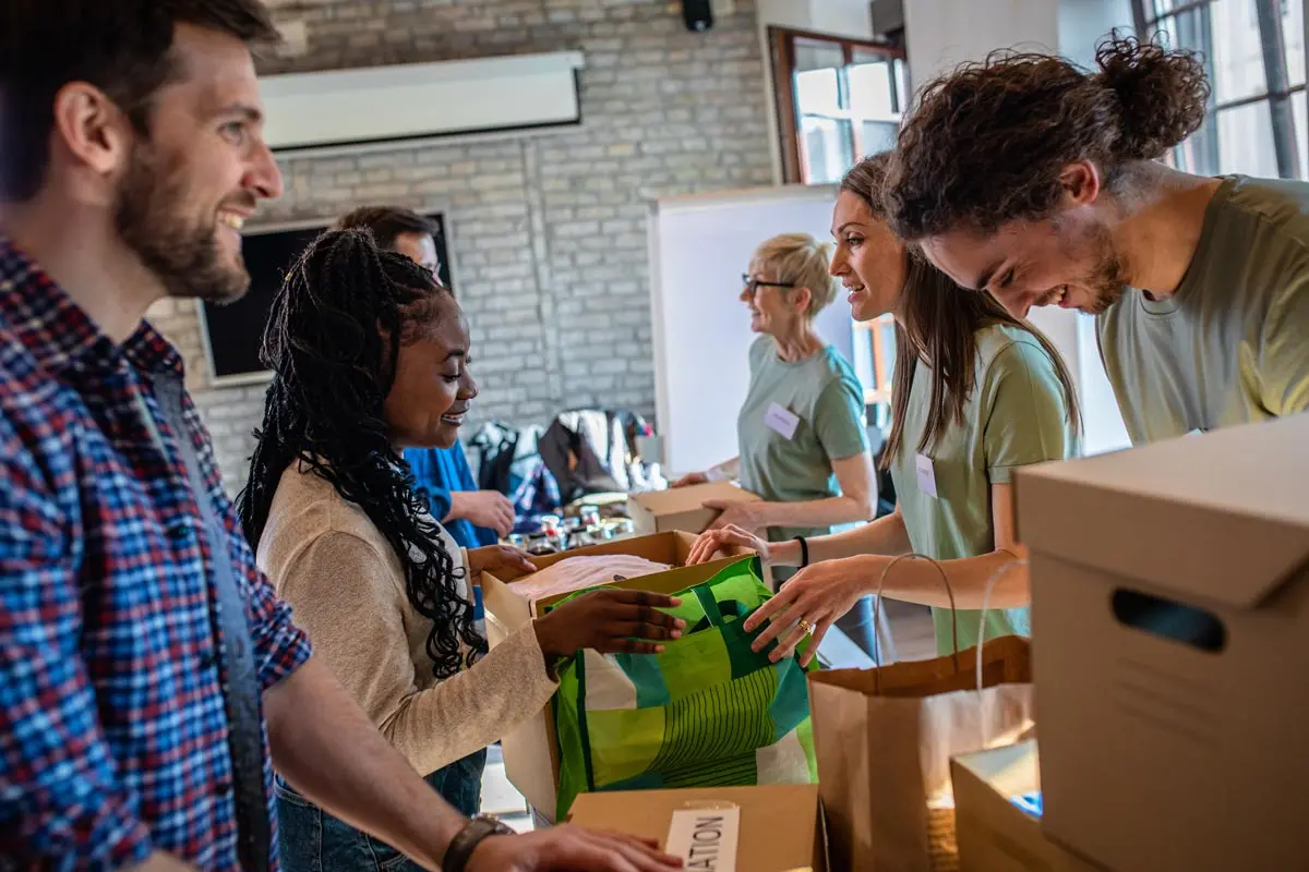 people volunteering with boxes of food