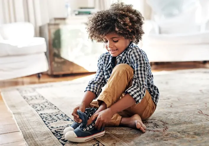 Boy putting on shoes