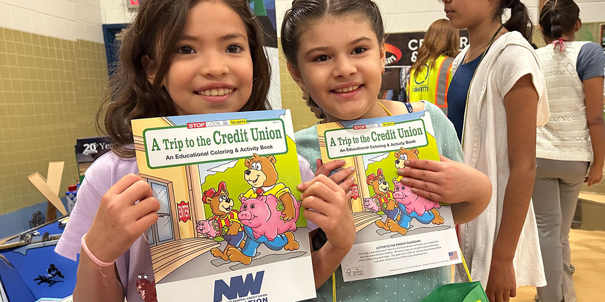Students learning financial literacy concepts in a classroom setting with educational materials and instructor.