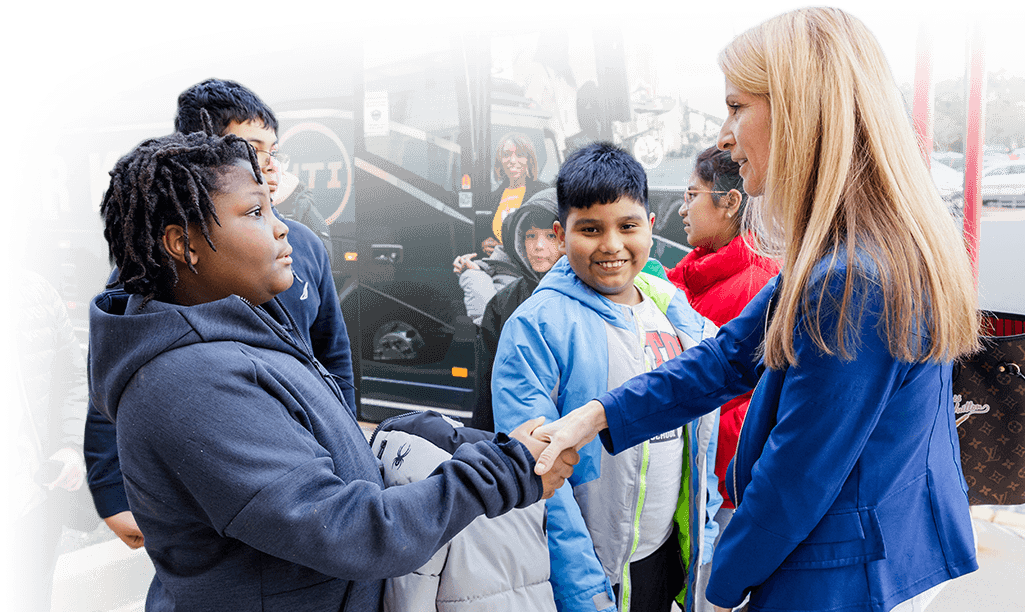 NWFCU Foundation mentorship program volunteer shaking the hand of a local student
